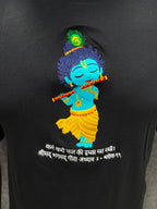 Close up of embroidered bal Krishna with flute and peacock feather on black cotton t-shirt with bagwadgita slok